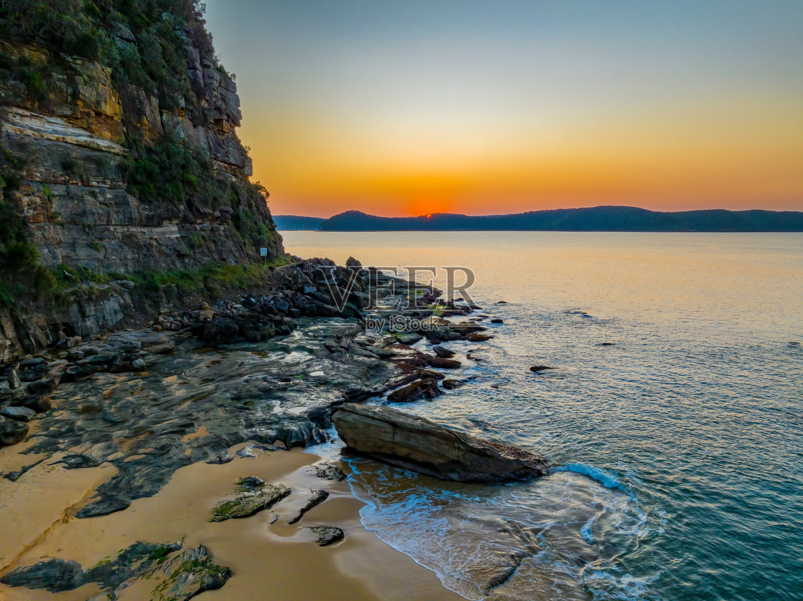 空中的日出在平静的海面上，烟雾笼罩着晴朗的天空照片摄影图片