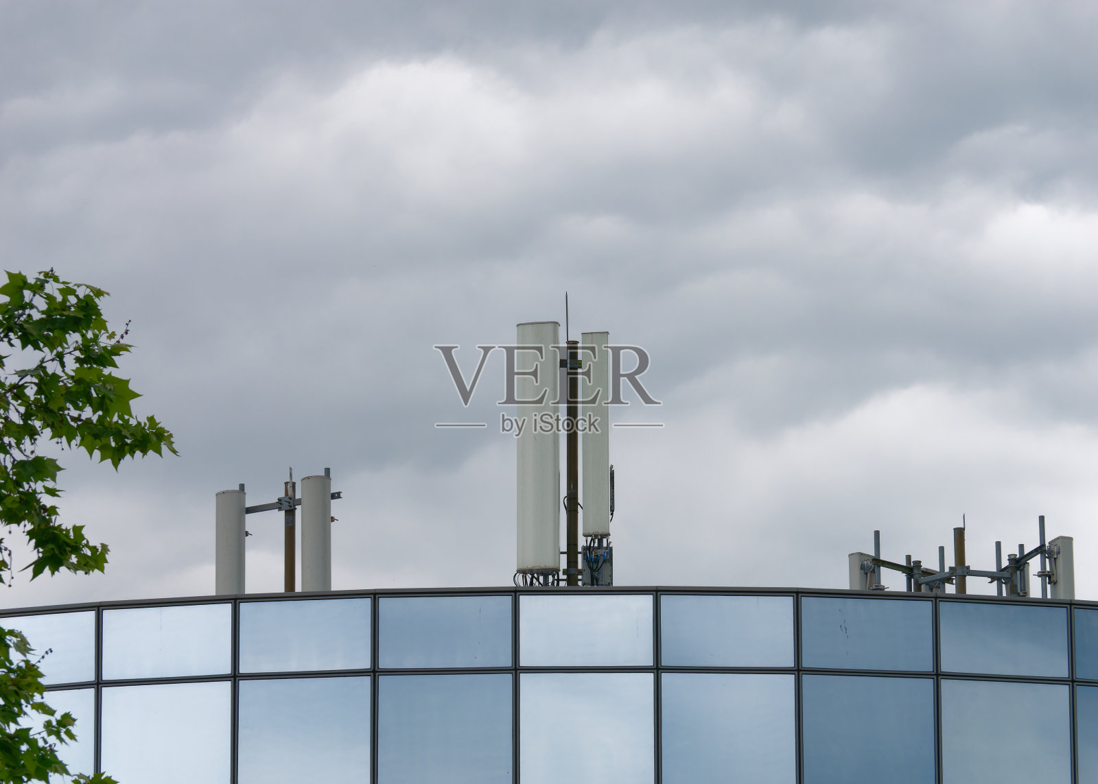 位于现代玻璃商业大楼顶部的手机基座照片摄影图片