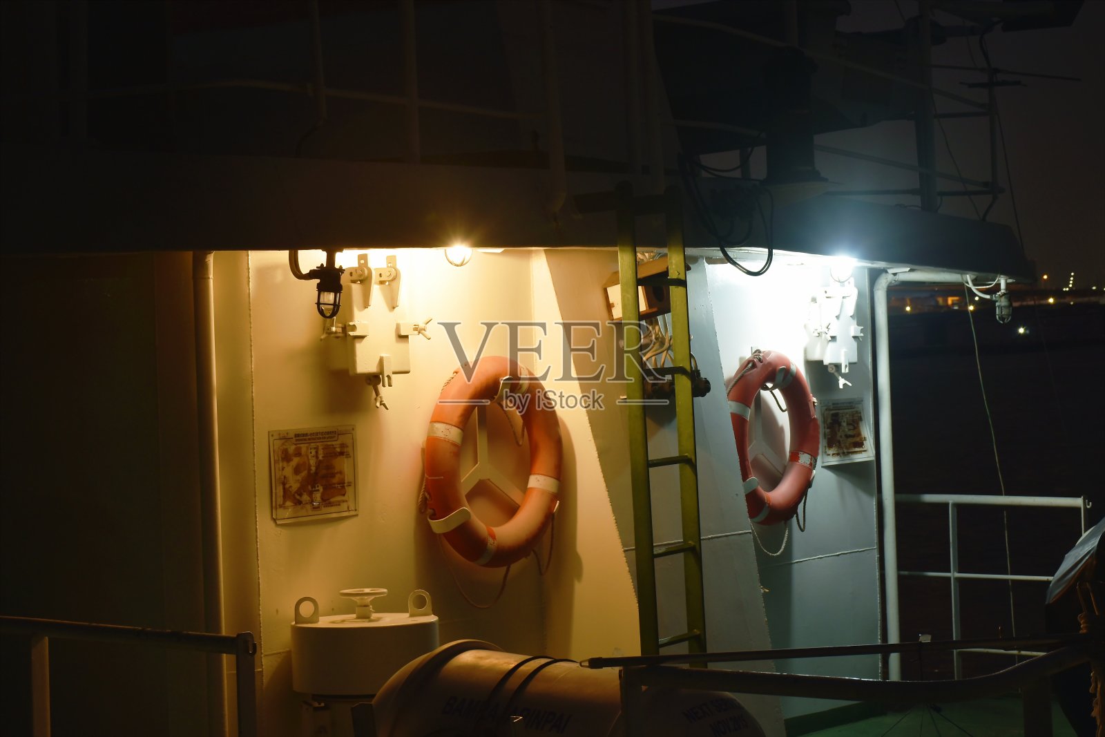 悬挂在船壁上的救生圈，电灯发出的光照片摄影图片