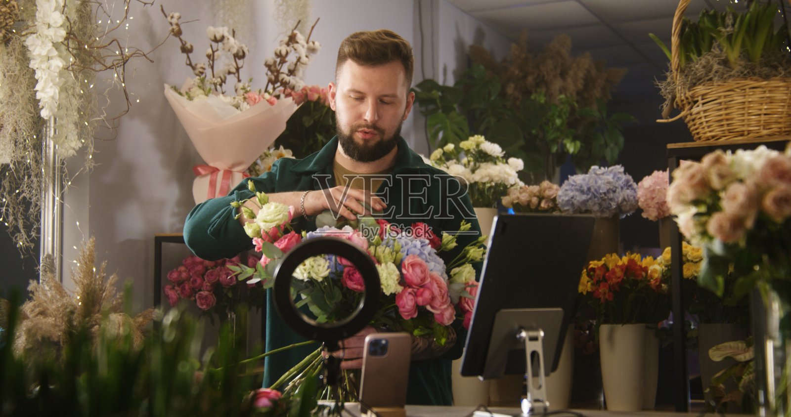 男花商收集花束和记录视频为博客使用手机和平板电脑照片摄影图片
