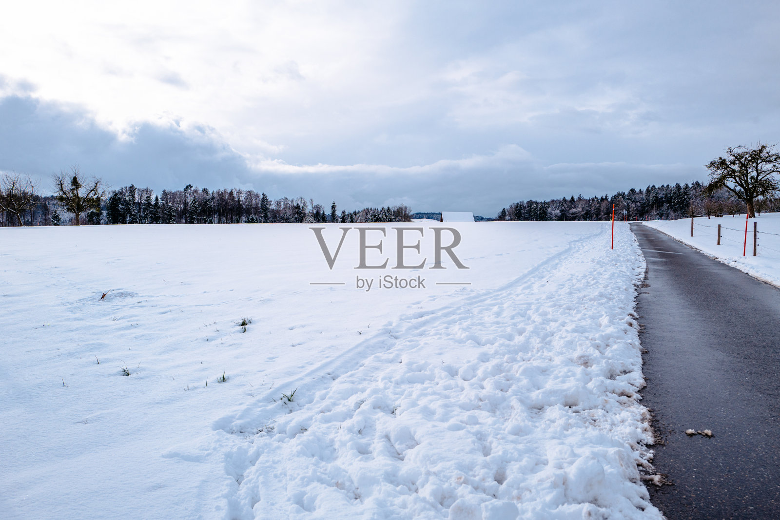 在多云的天空下，白雪覆盖的田野照片摄影图片