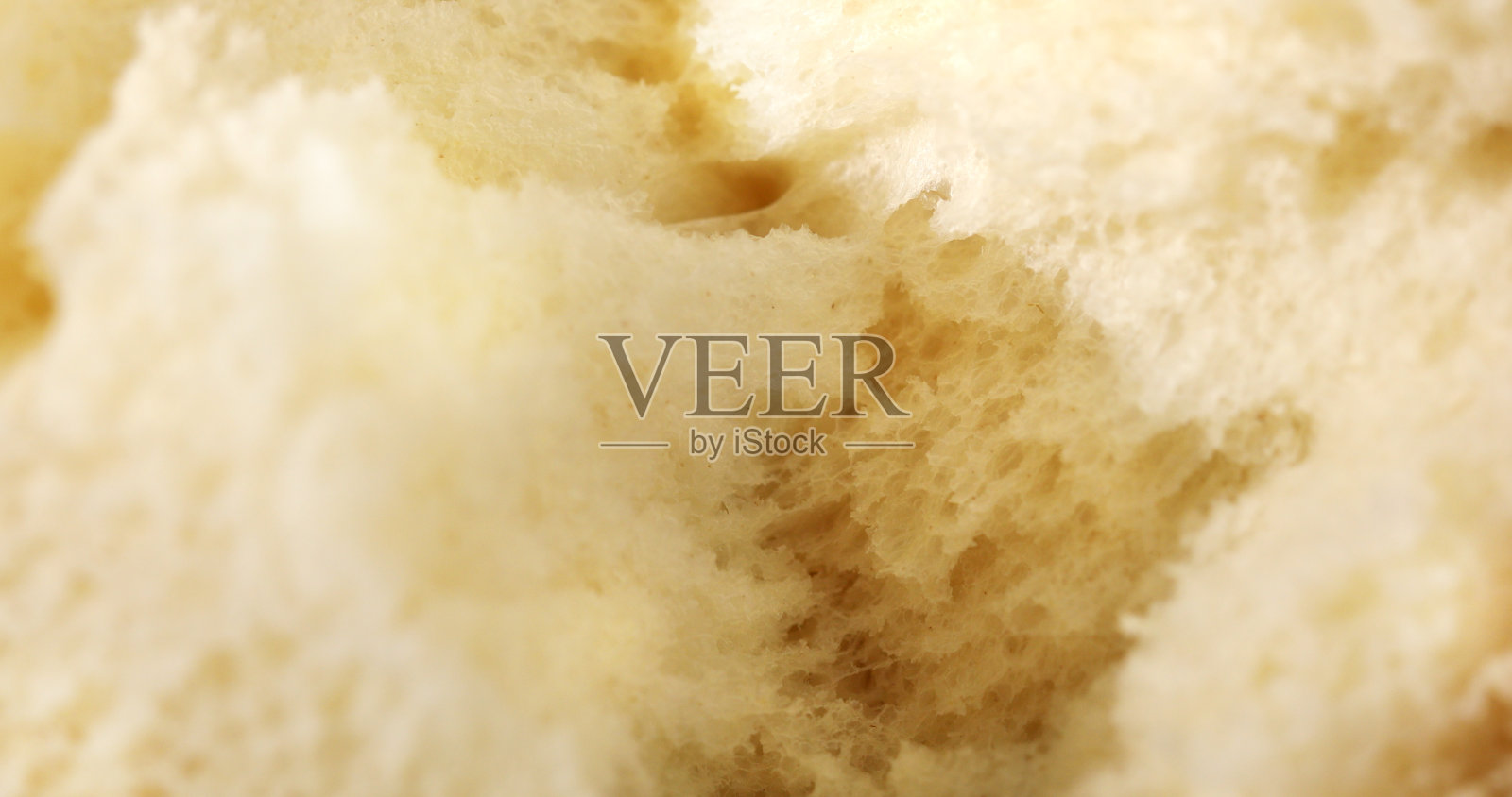 撕新鲜的面包。近距离观察面包的质地。照片摄影图片