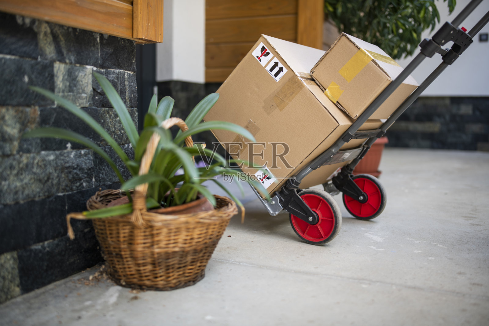 门边有一辆载着包裹的手推车。照片摄影图片