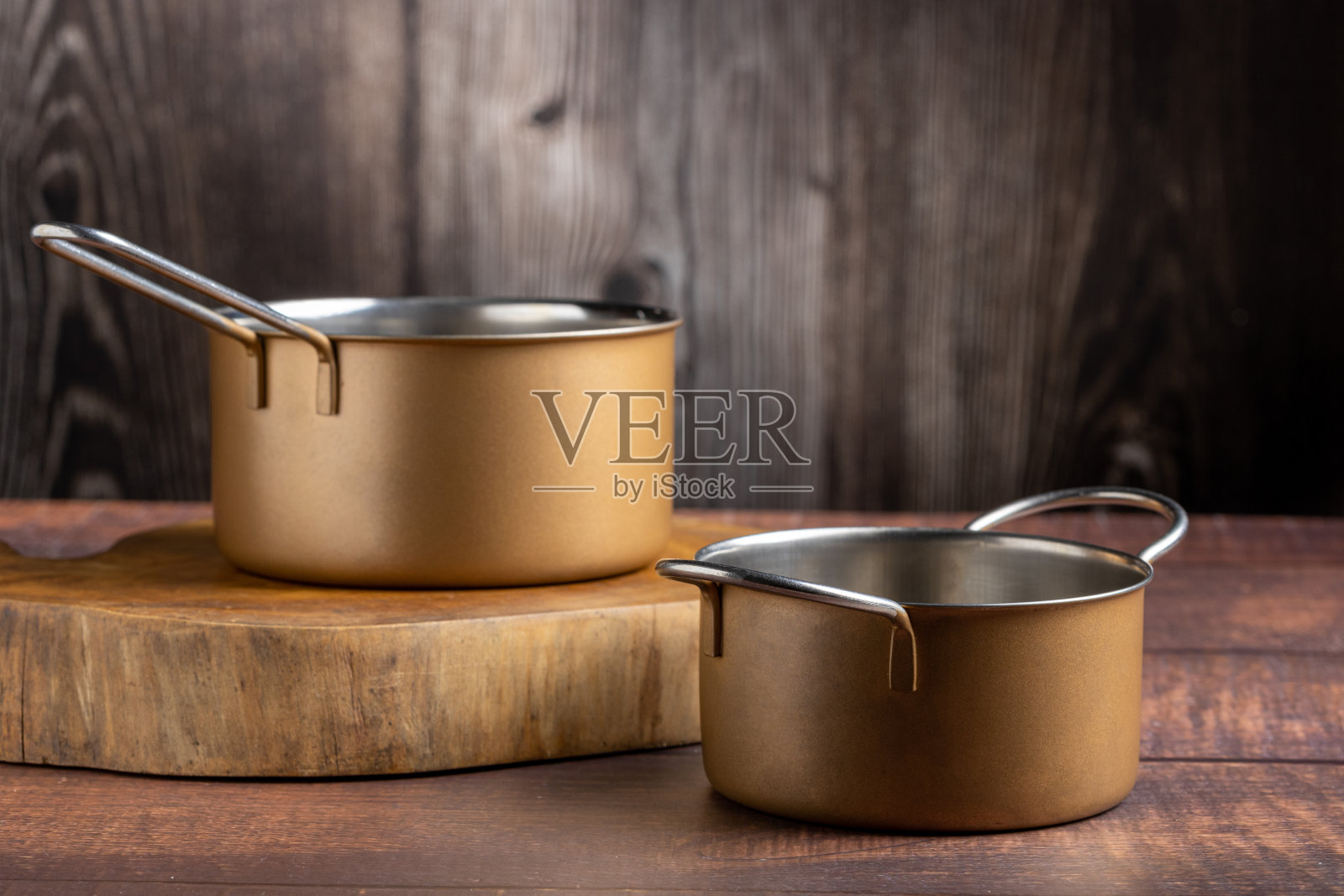 桌子上有一套炊具。金属锅。照片摄影图片