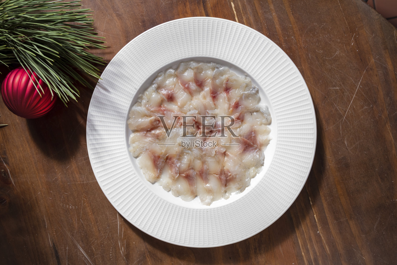 餐桌上用圣诞装饰的盘子里的生鱼片照片摄影图片