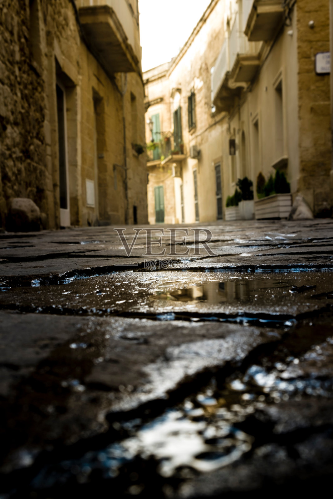 建筑物中潮湿的鹅卵石街道的表面水平视图照片摄影图片