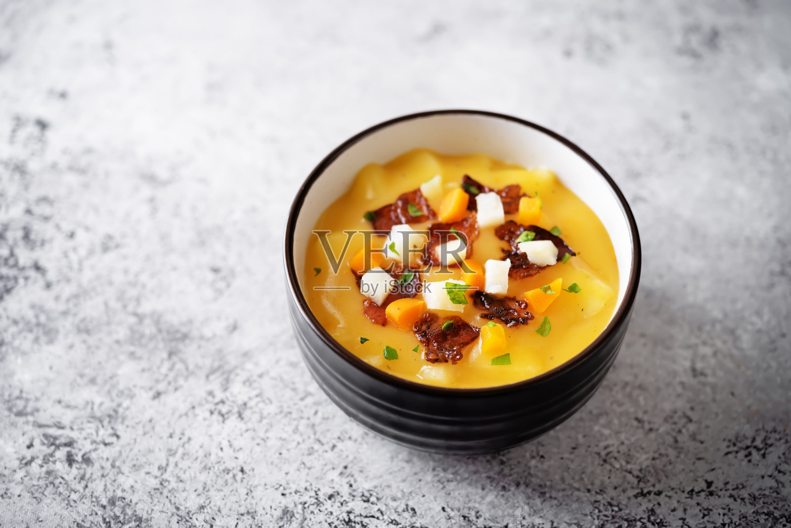 土豆胡萝卜汤煎培根片在碗里照片摄影图片