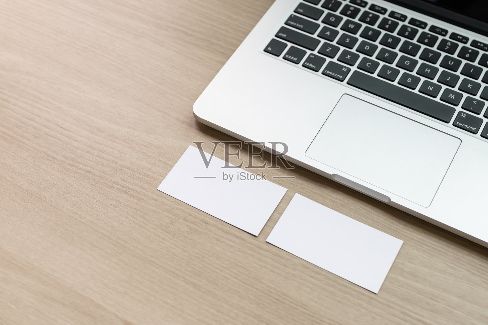会议室桌上放着一台笔记本电脑，递上一张横着的名片。空白卡片，模型照片摄影图片