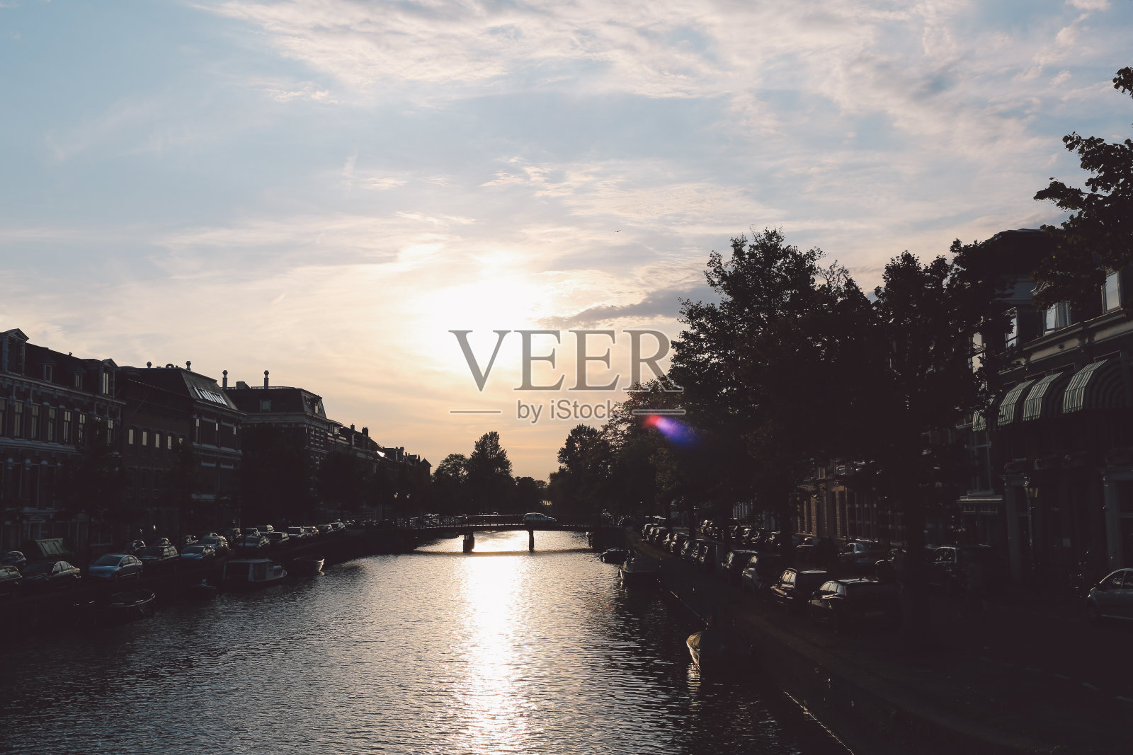 日落时，河流在建筑物间映着天空照片摄影图片