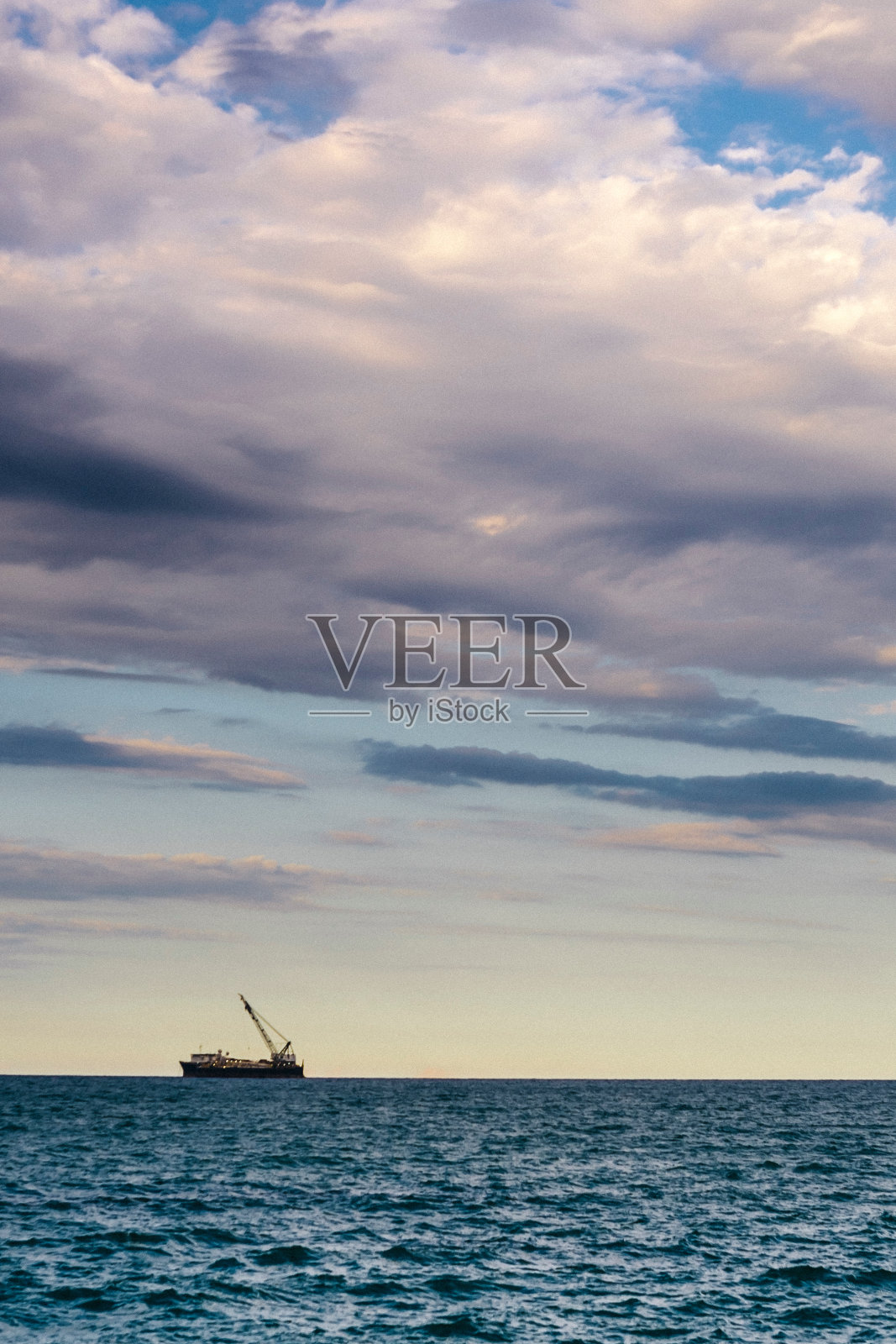 船在海上航行，黄昏时天空多云照片摄影图片