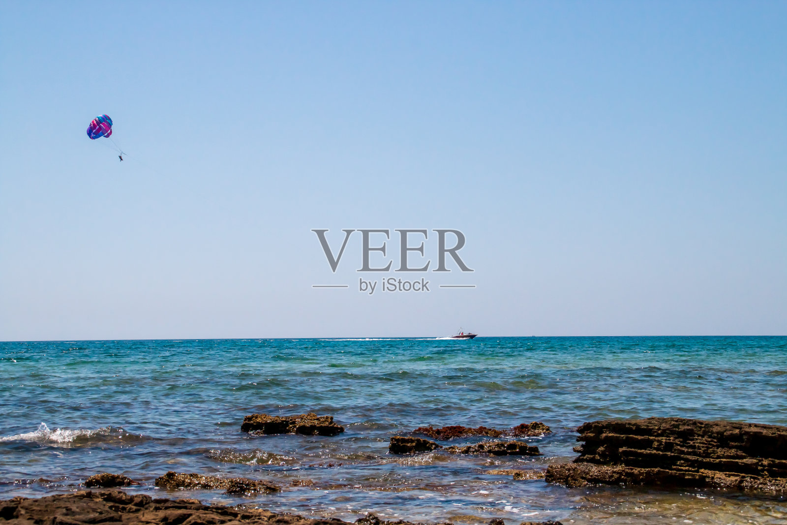 在意大利普利亚的Marina di Salve，水上活动在爱奥尼亚海上空跳伞。照片摄影图片