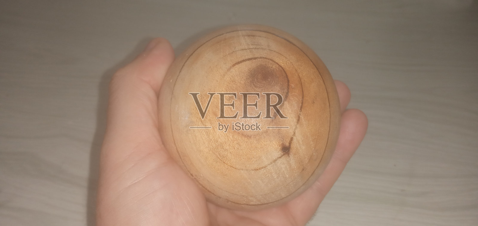 手握木球照片摄影图片