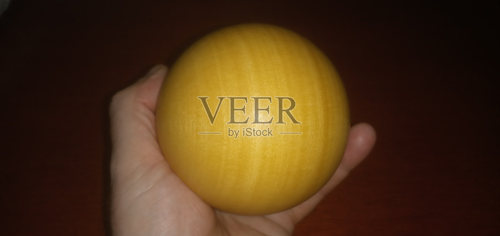 手握木球照片摄影图片