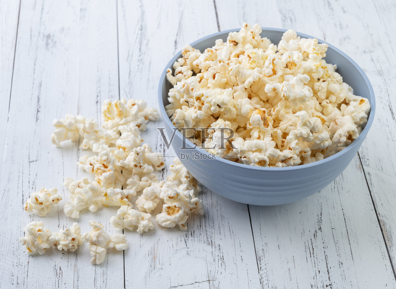 木桌上的碗里放着爆米花照片摄影图片