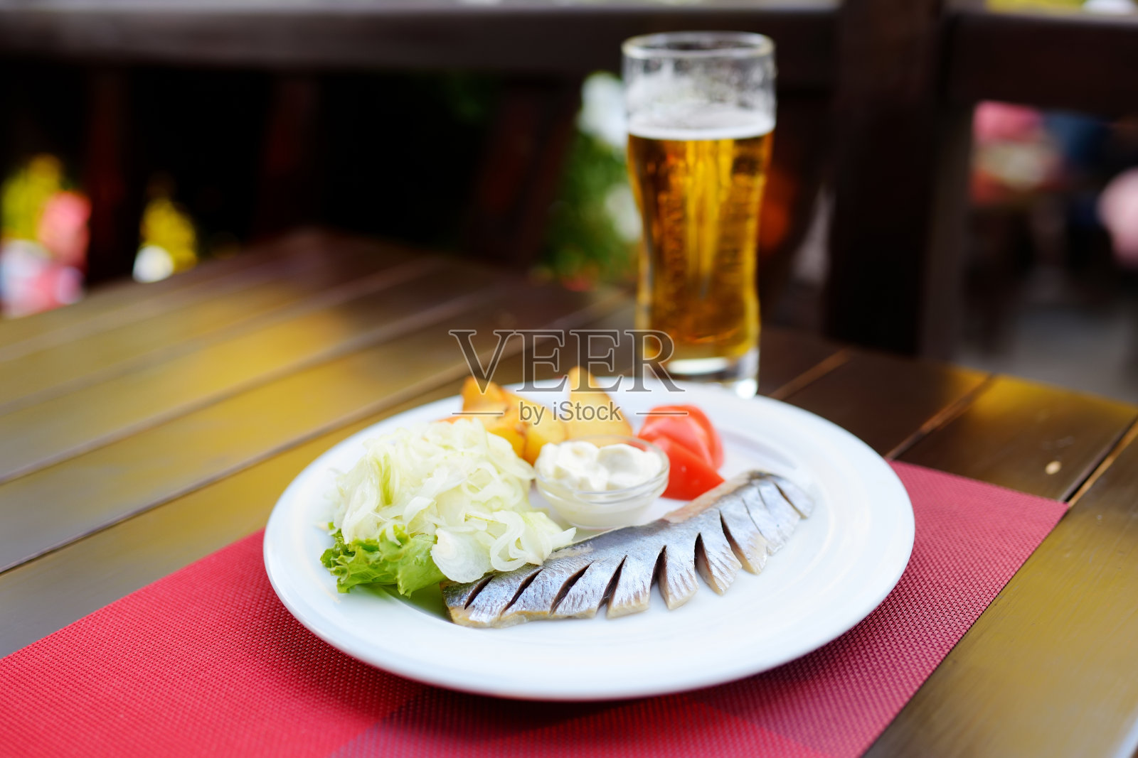 传统的立陶宛腌鲱鱼配酸奶油，新鲜蔬菜和热煮土豆。照片摄影图片