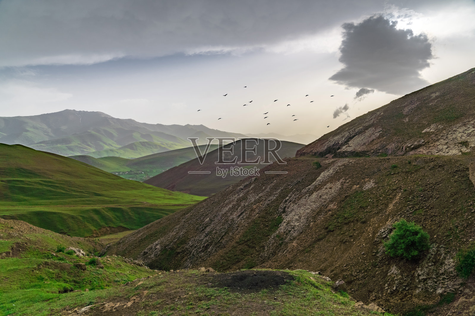多云的天气里，长满绿草的山景照片摄影图片