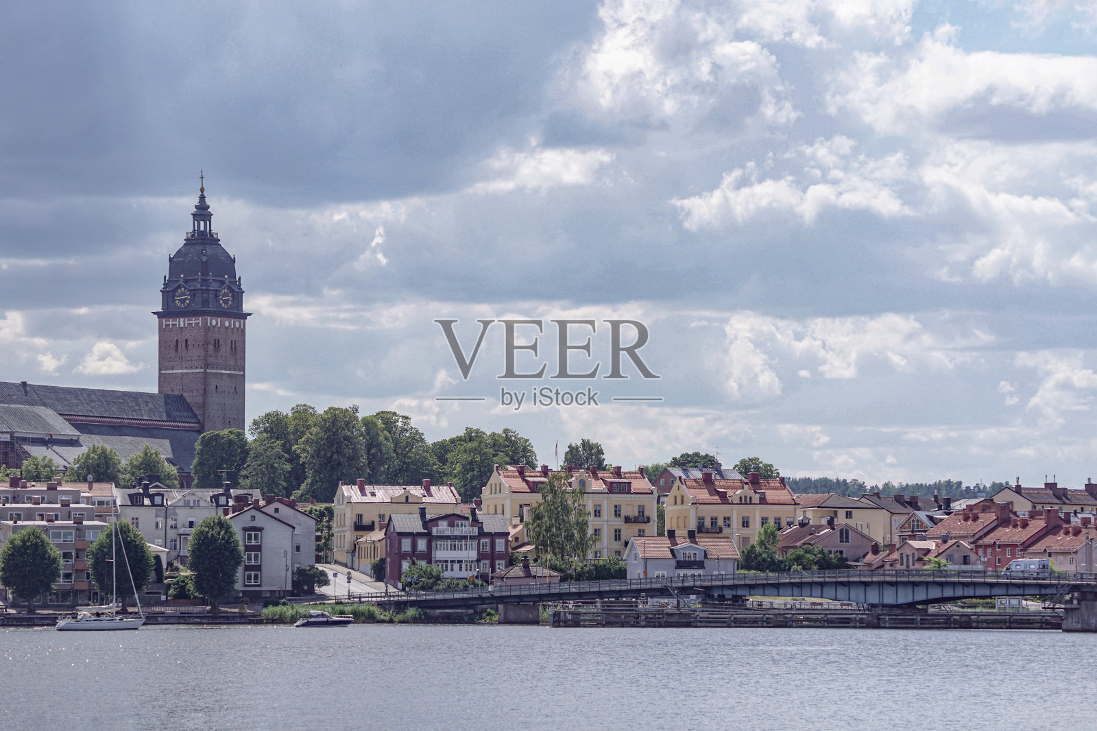 多云的天空映衬着河边的建筑物照片摄影图片