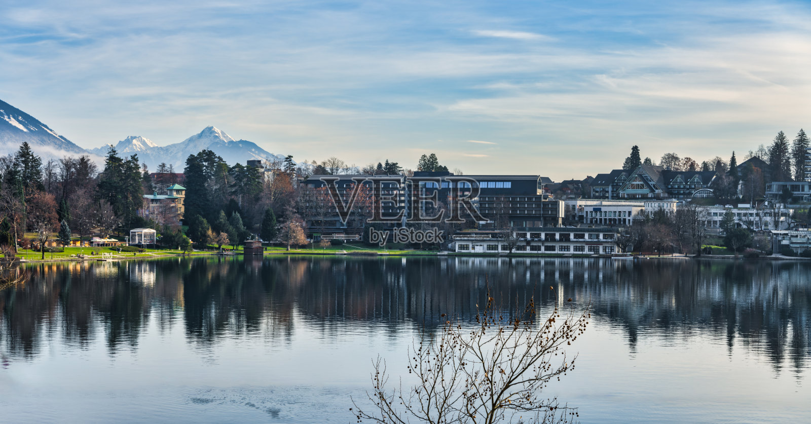 在一个晴朗的冬季下午，斯洛文尼亚，布莱德镇建筑在布莱德湖上的全景照片照片摄影图片