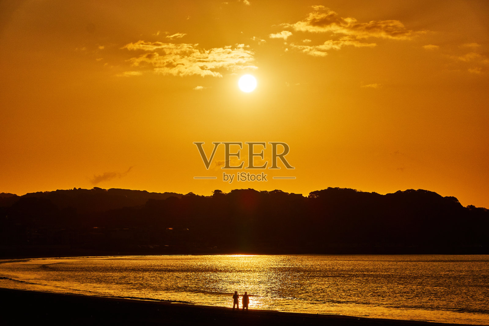 日出时，海滩对着阴沉的天空的美景照片摄影图片