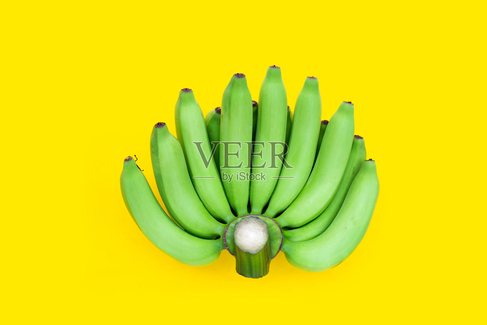 黄色背景上的绿香蕉照片摄影图片