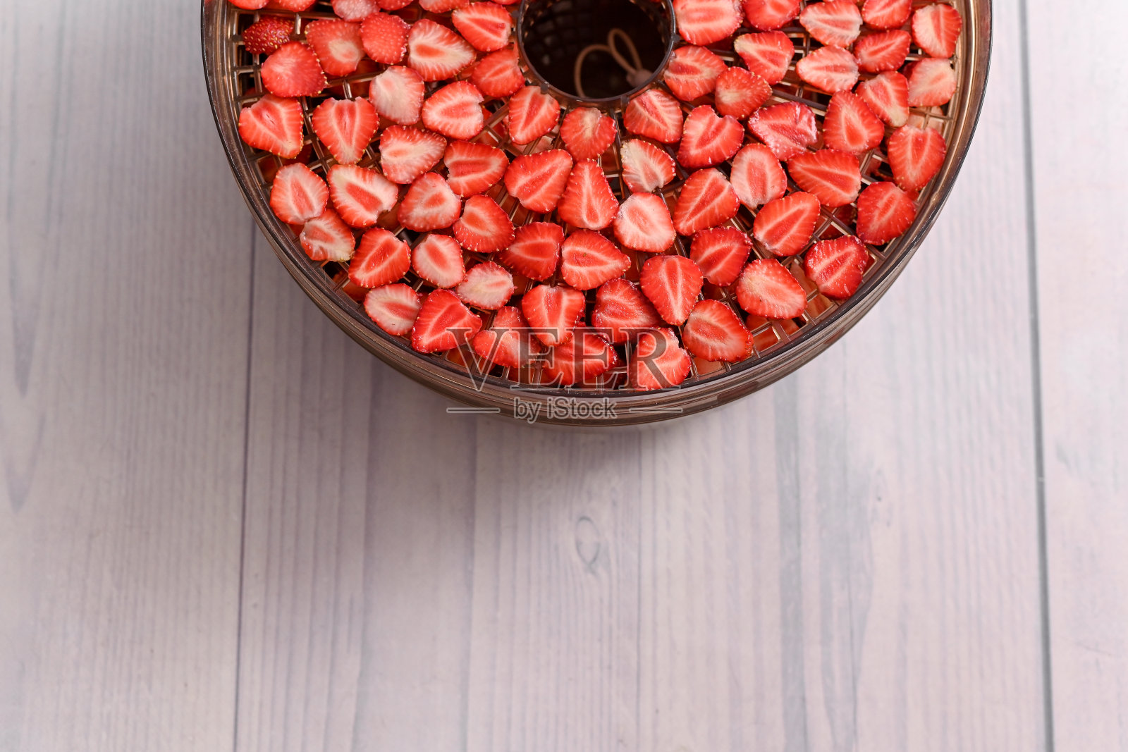 干燥浆果的脱水机。把草莓切片晾干。照片摄影图片