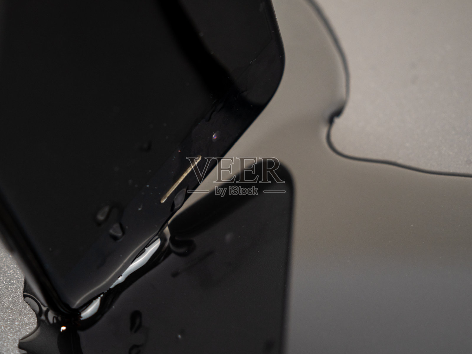 水洒在了智能手机上。智能手机掉进水里了。照片摄影图片