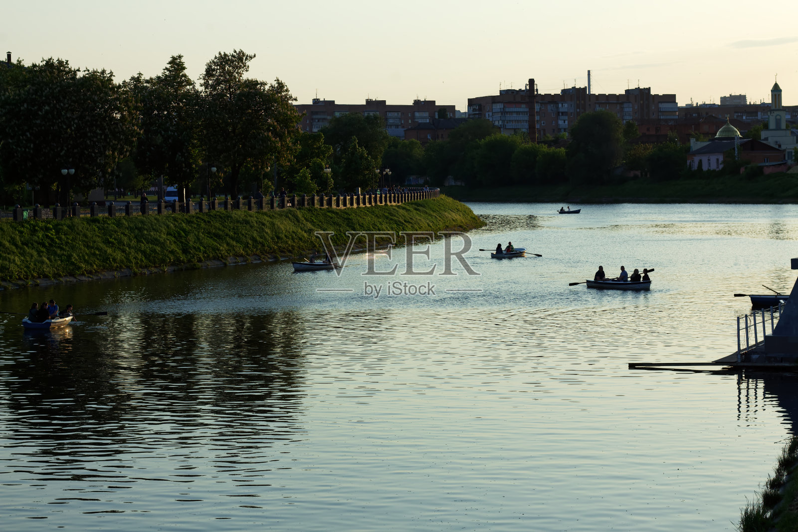 傍晚时分，哈尔科夫市中心的河流上，人们乘船漂浮照片摄影图片
