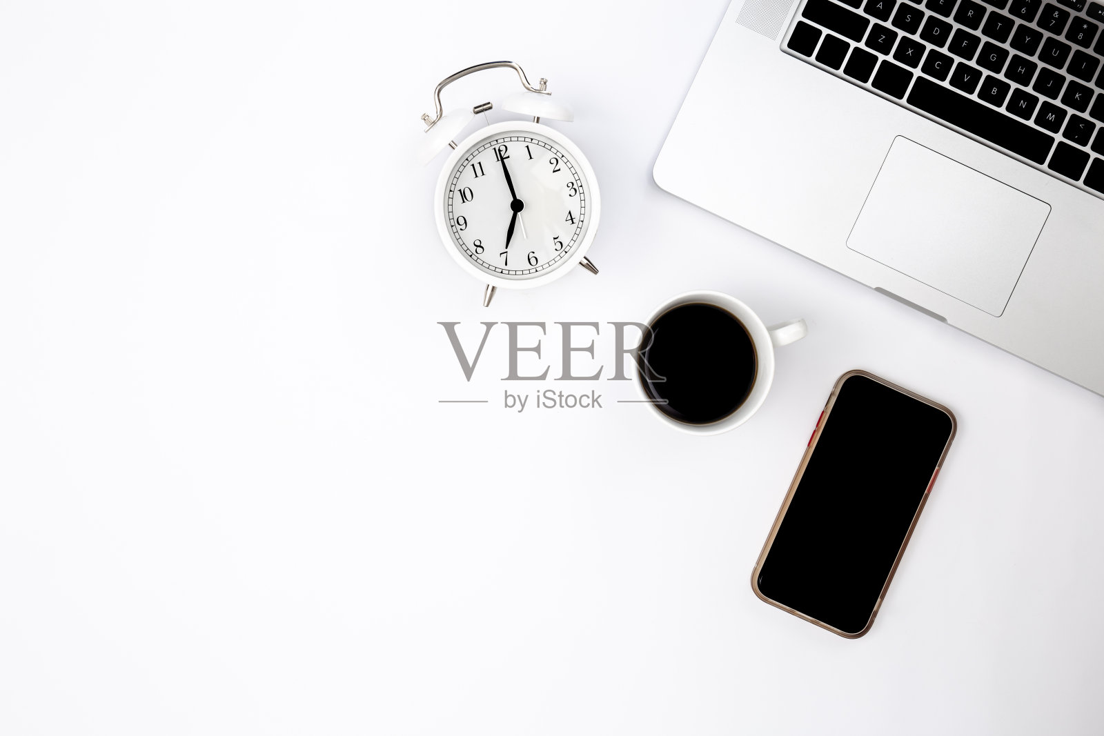 白色背景，笔记本电脑，智能手机，闹钟和黑色咖啡杯。照片摄影图片