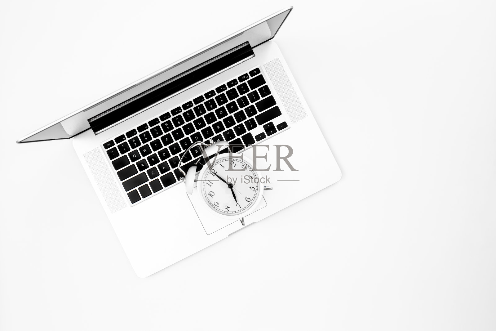闹钟和笔记本电脑，白色背景，俯视图。照片摄影图片