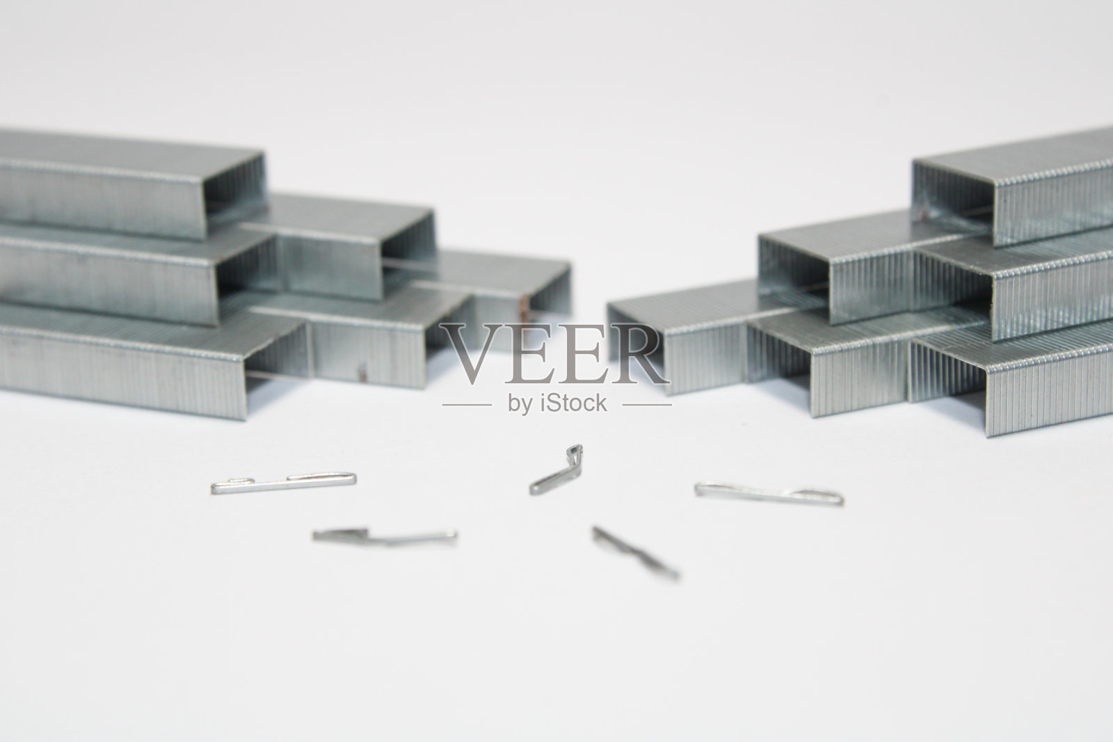 在白色背景上为订书机隔离的金属订书钉堆的近照照片摄影图片