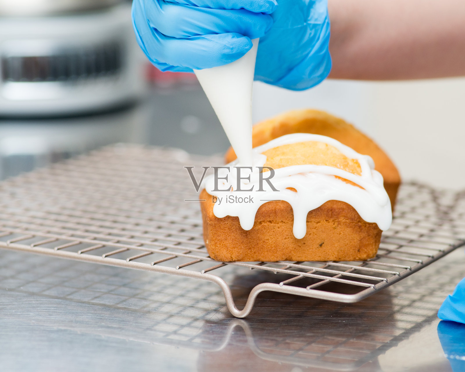 把奶油釉涂在面包店的蛋糕上照片摄影图片