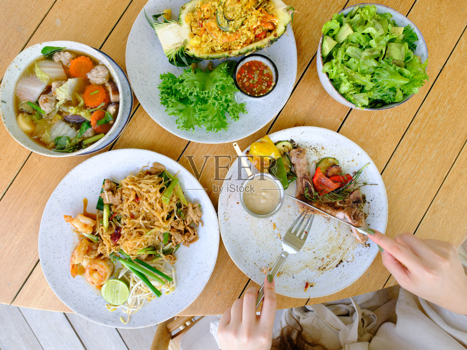 年轻女性在餐厅吃牛排和其他食物照片摄影图片