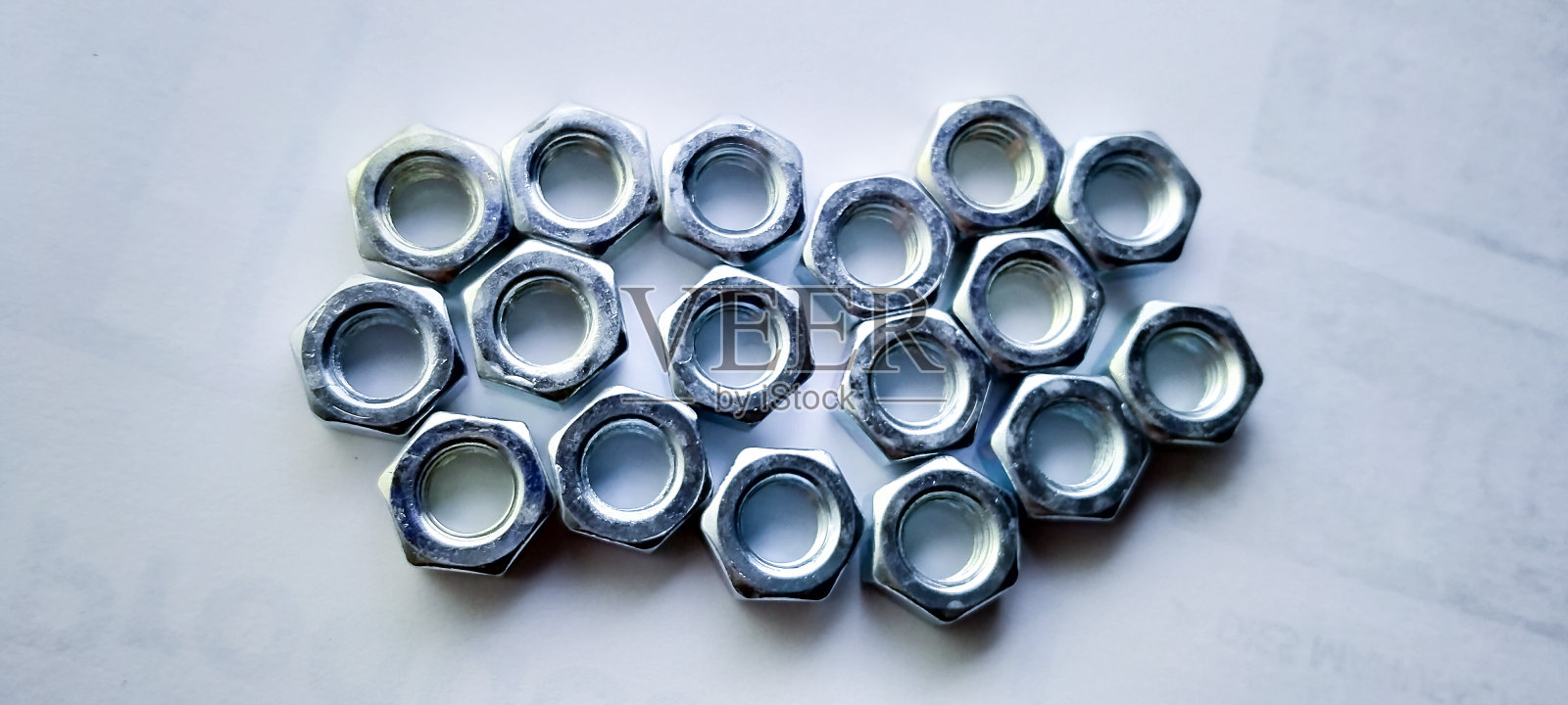 白色桌子上的六角螺母。照片摄影图片