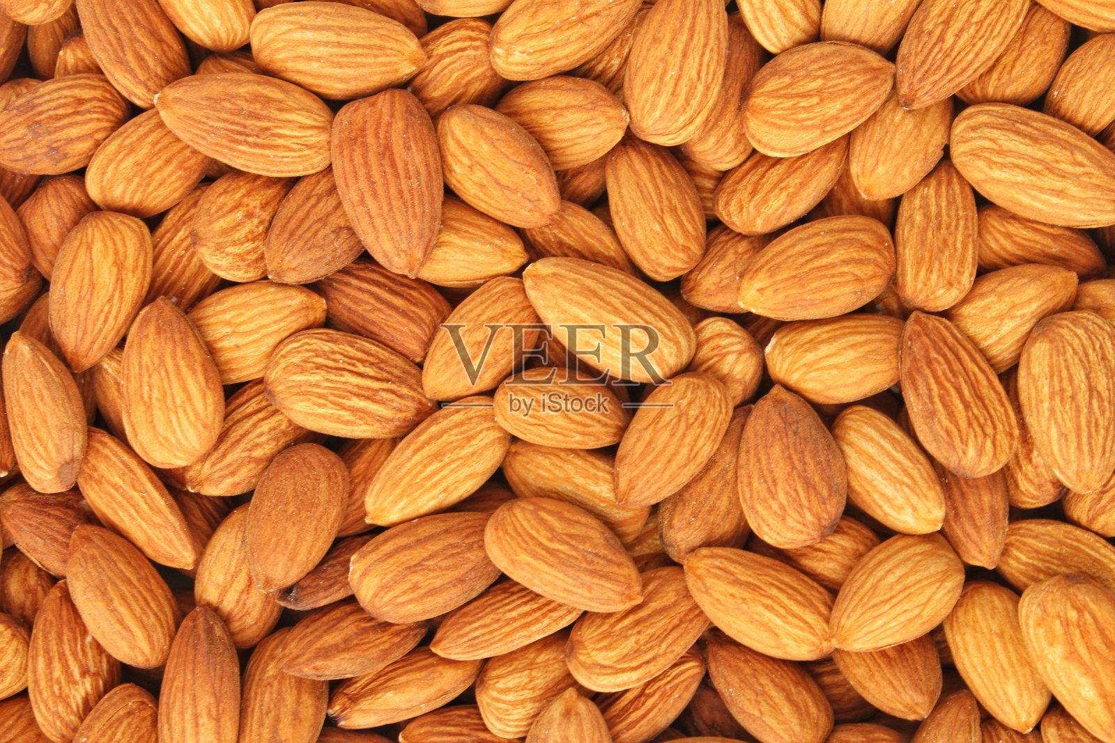 一堆杏仁种子特写作为背景。一堆去皮的杏仁。健康饮食，营养饮食，素食理念照片摄影图片