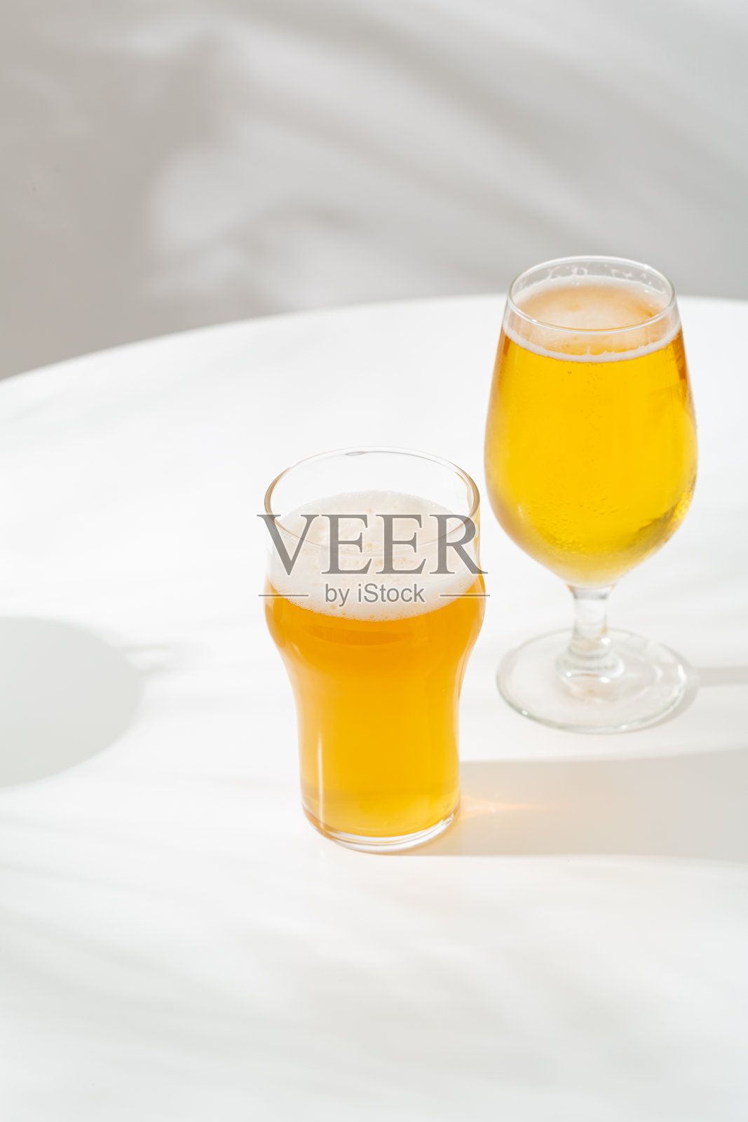 白桌子上放着两品脱淡啤酒照片摄影图片