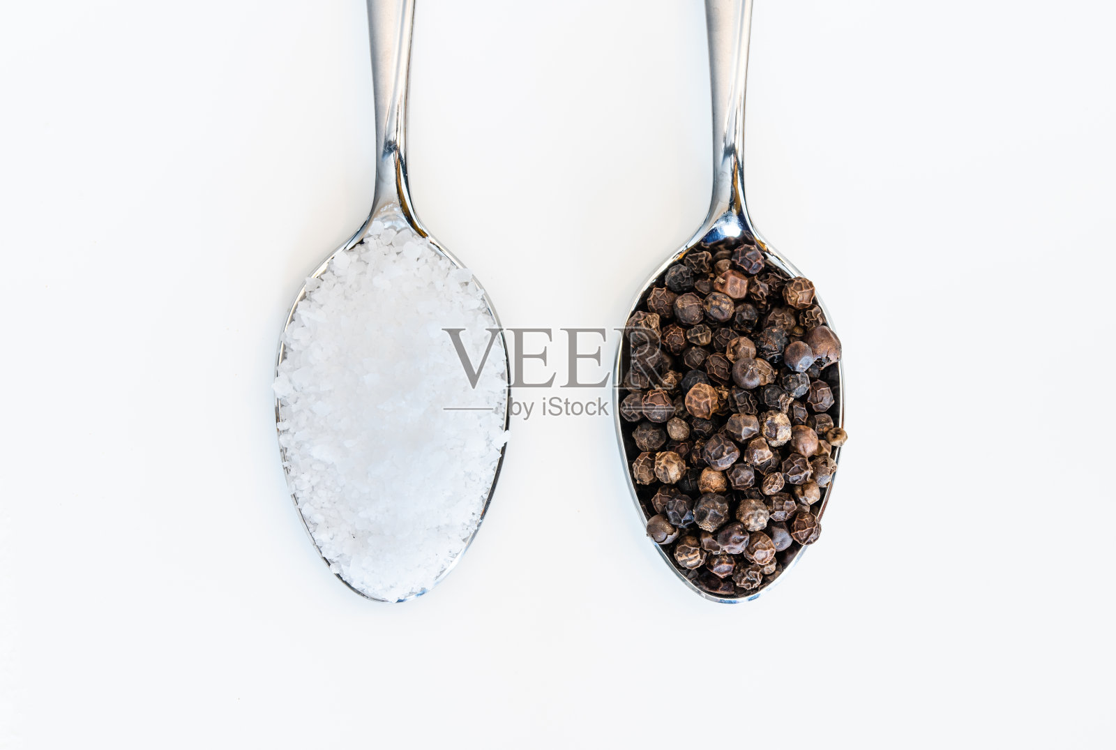 一勺食盐和黑胡椒，背景是白色的照片摄影图片