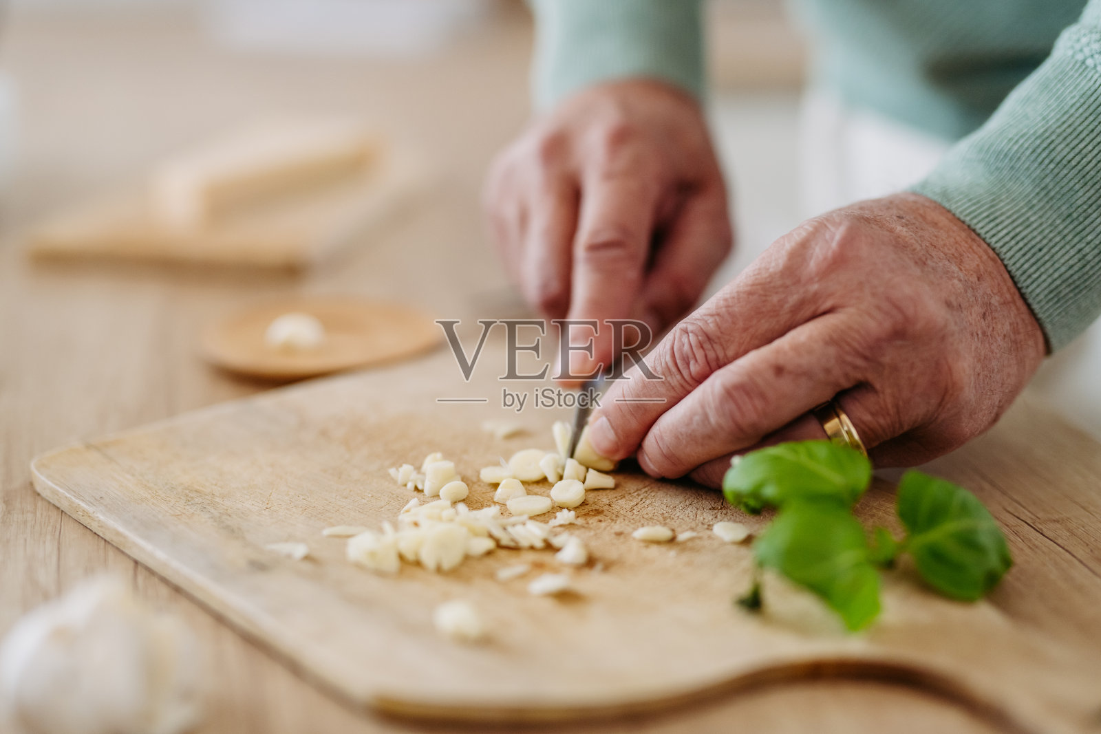 老人切大蒜的特写。照片摄影图片