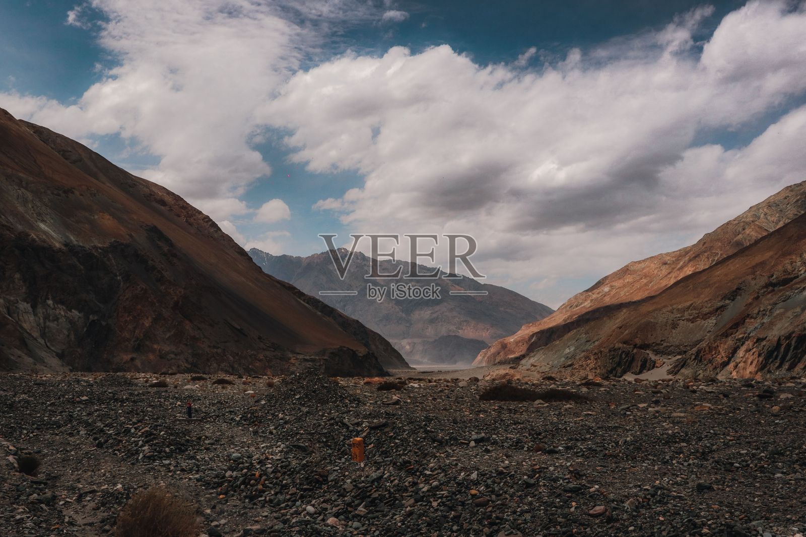 一条铺砌的道路蜿蜒穿过荒凉的风景，映衬着贫瘠的山脉照片摄影图片