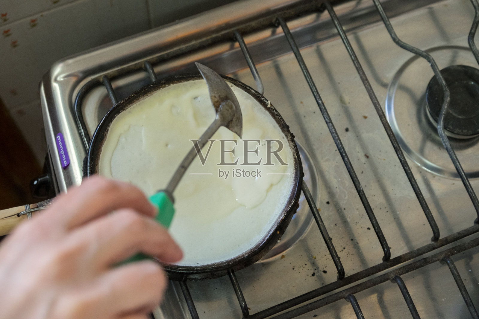 厨师在炉子上的平底锅里煮玉米饼的特写照片摄影图片