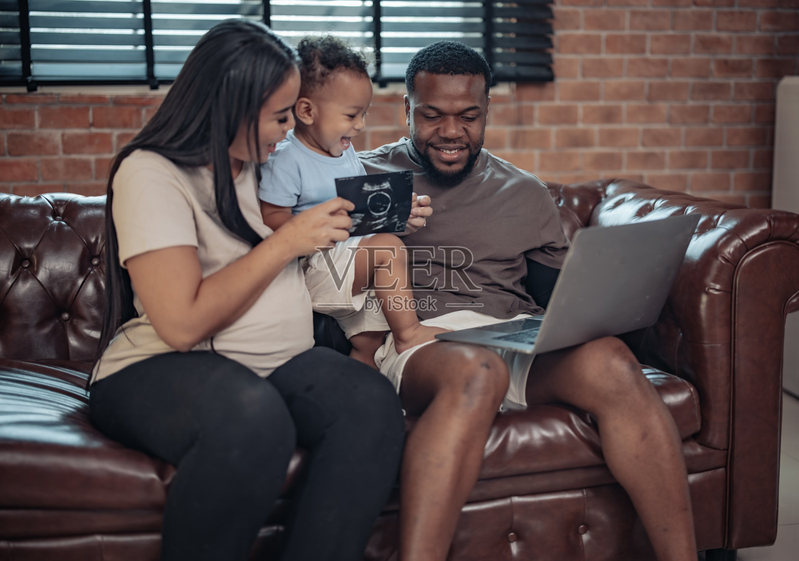 家庭成员看到超声图像显示性别，健康，发育婴儿在母亲的子宫里，充满了喜悦，欢呼和兴奋。未来需要奉献、努力和耐心。照片摄影图片