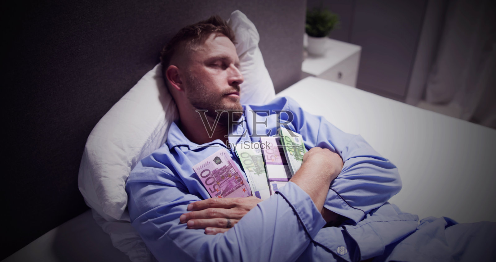 男人抱着包裹睡在床上照片摄影图片