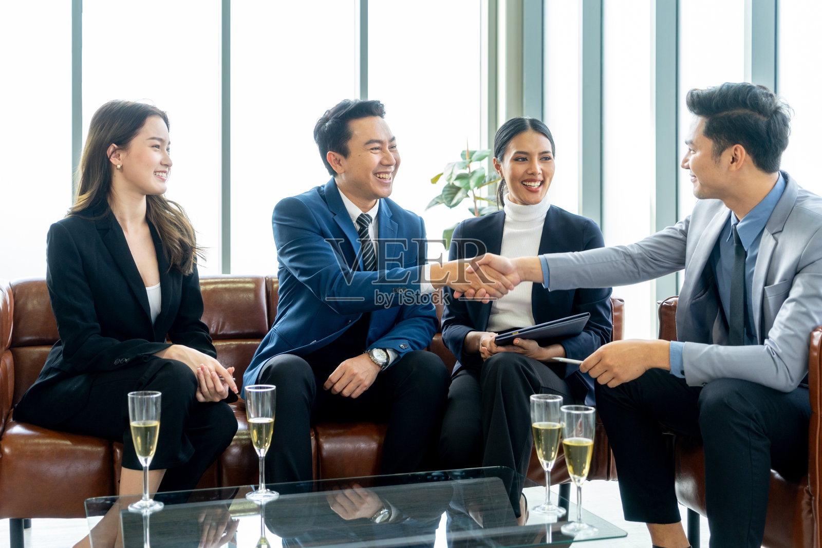 一小群商务人士在现代化的办公室里与投资者会谈后签订合同照片摄影图片