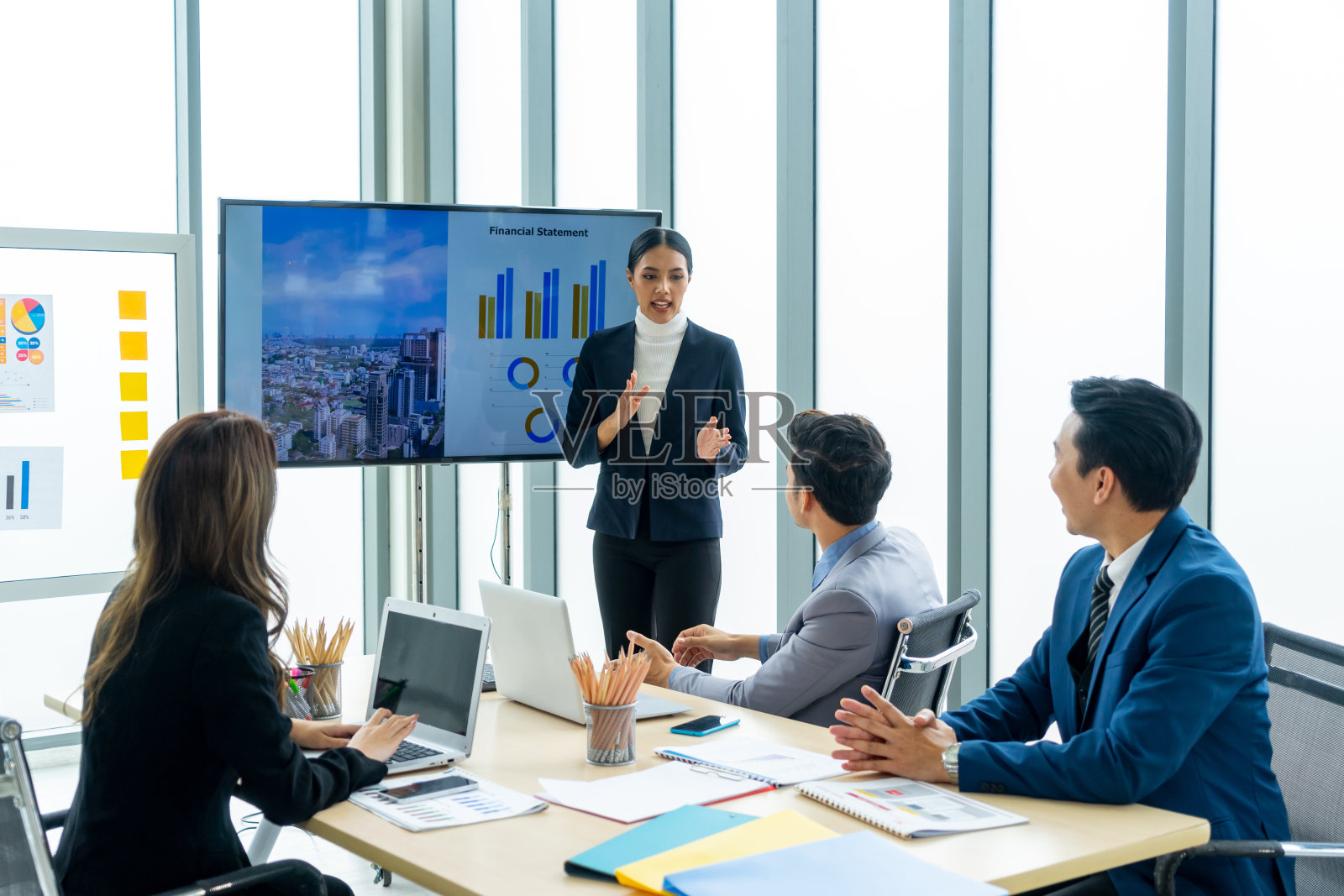 女商人在会议室的屏幕上向同事展示投资活动计划照片摄影图片