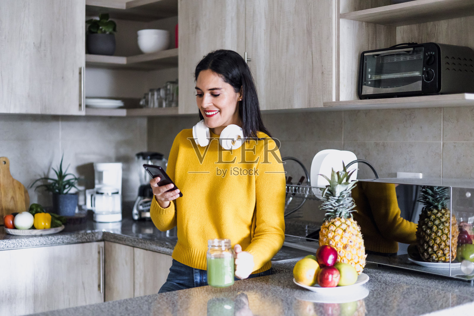 拉丁美洲，拉丁裔女性在墨西哥家里的厨房里喝排毒饮料或绿色果汁照片摄影图片