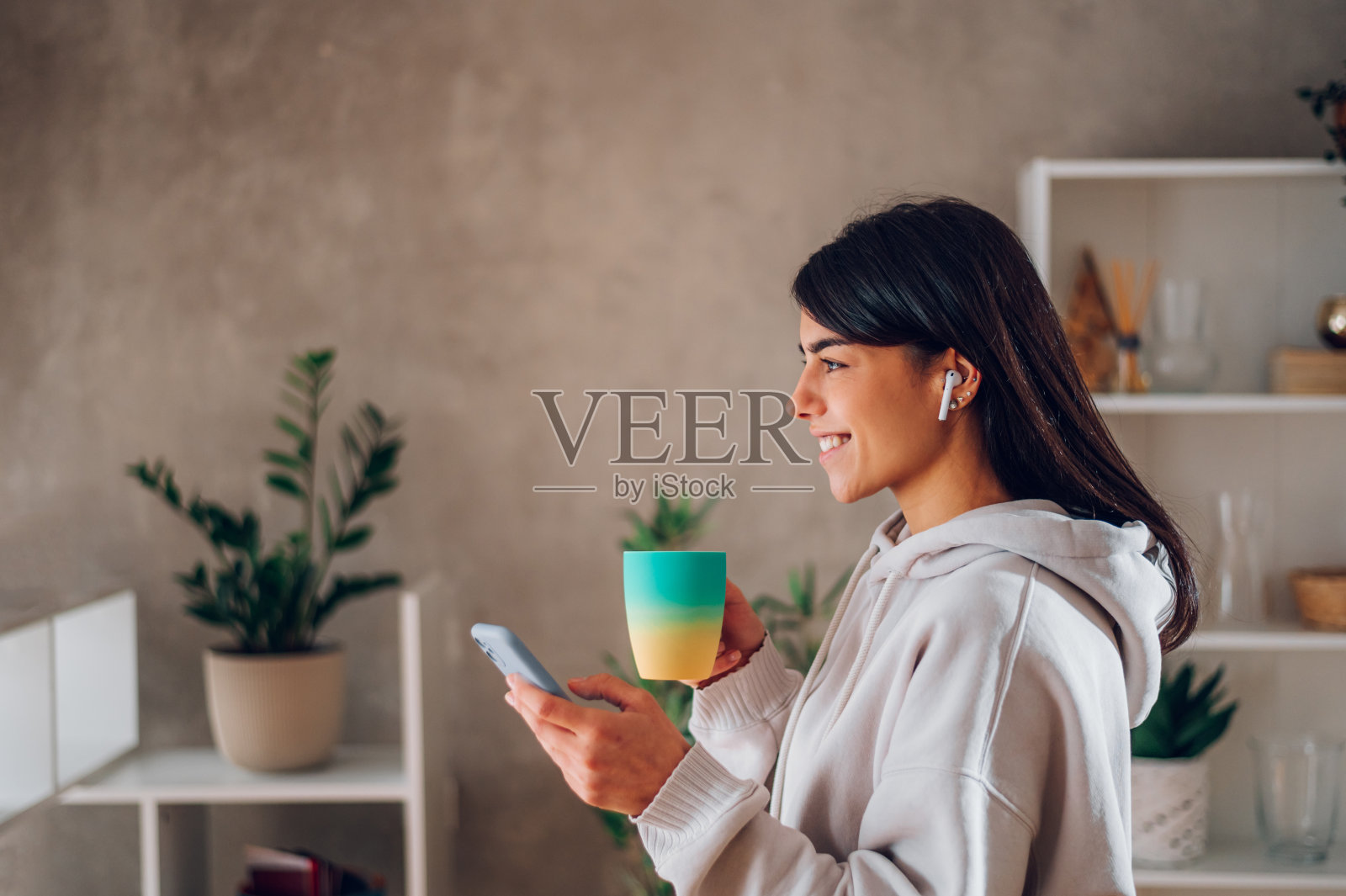 一个在家里用智能手机喝咖啡的美女的画像照片摄影图片