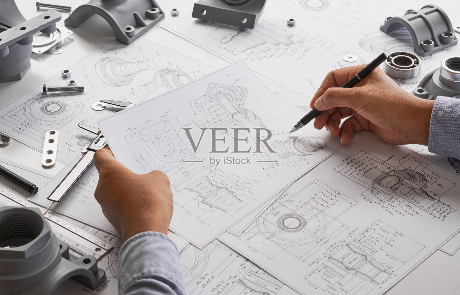 技术员设计机械零件图纸：工厂工业项目蓝图，测量轴承卡尺照片摄影图片