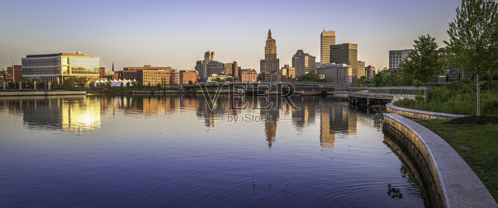 普罗维登斯市中心的天际线和日出时的建筑物，罗德岛州首府河上平静的水面倒影照片摄影图片