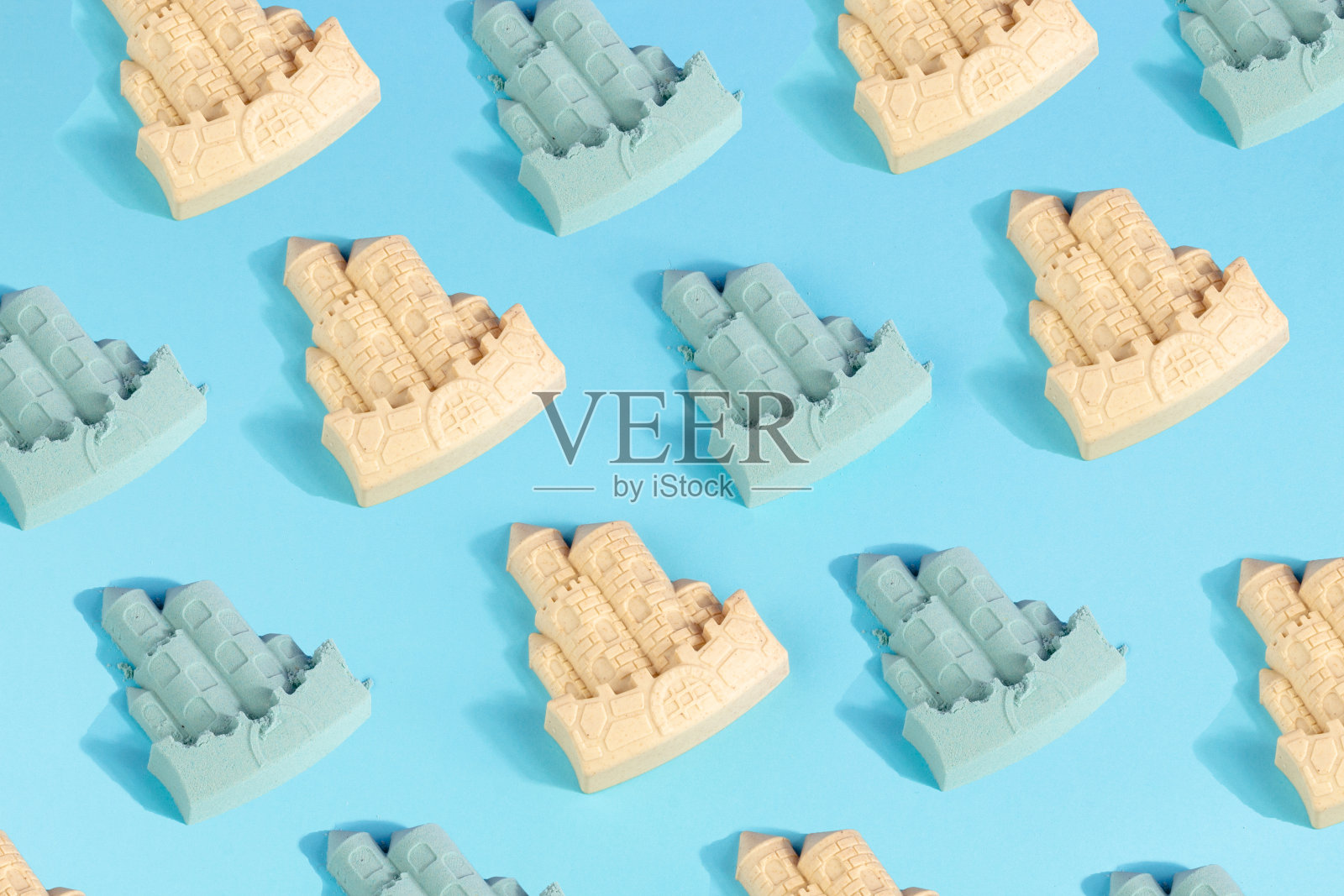 蓝色的沙城堡和城堡模具图案的夏季海滩概念在蓝色的背景照片摄影图片