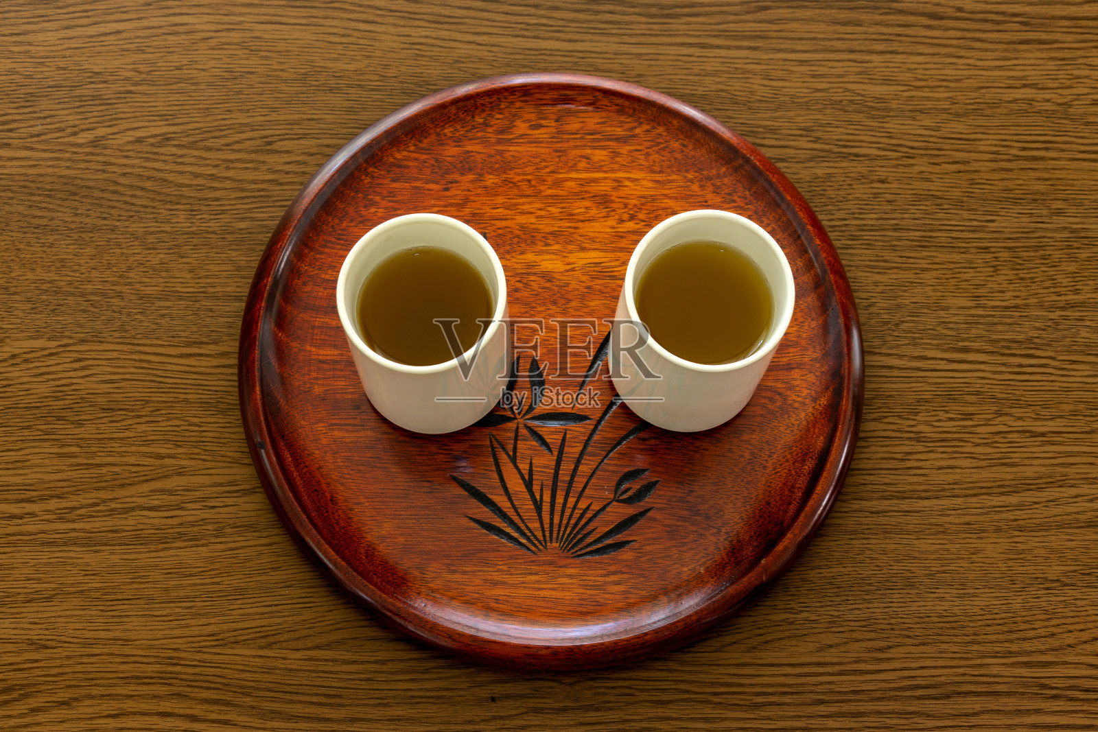 木制圆托盘上盛着绿茶的日式茶杯照片摄影图片