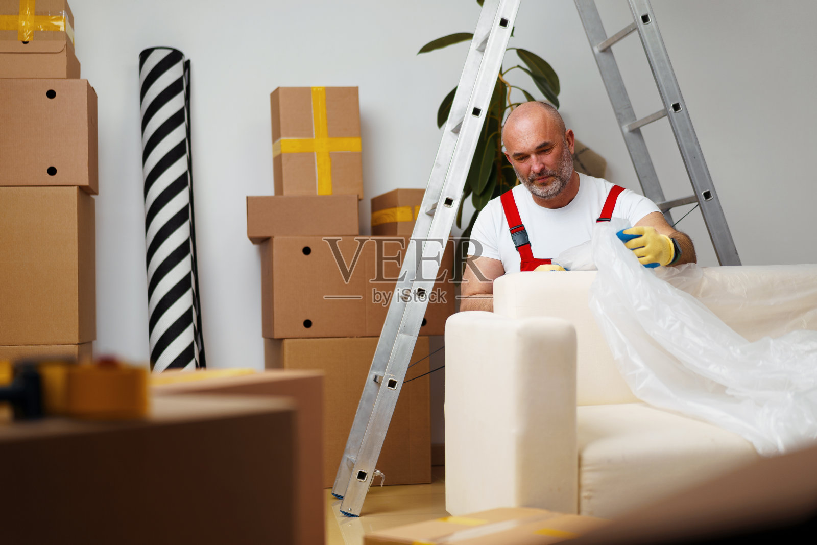 搬运工人在统一的包装沙发上进行搬迁照片摄影图片